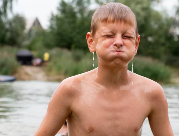 一个白人男孩从湖中浮出水面 水从他的脸上流下来 — 图库照片