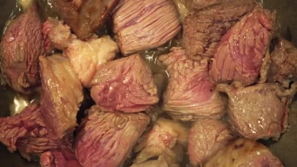 Raw pieces of beef meat fried in a pan closeup — Stock Video