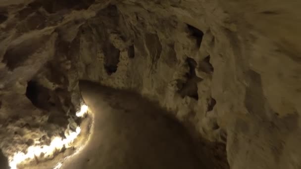 在岩石中挖空的黑暗隧道中行走 — 图库视频影像