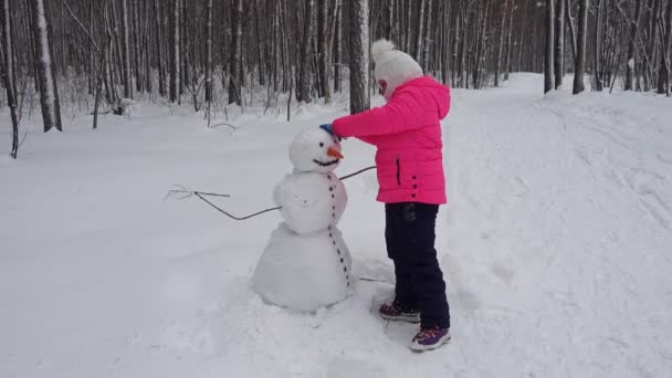 Menina Faz Boneco Neve Floresta Inverno — Vídeo de Stock