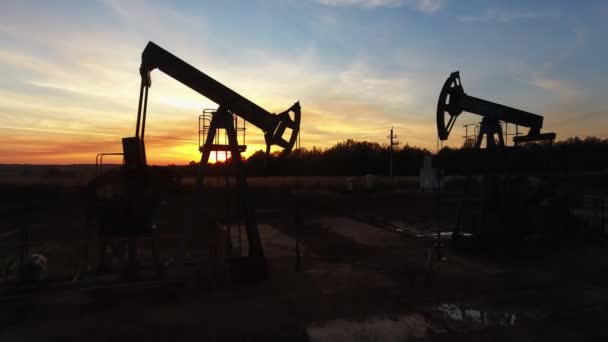 在落日的天空背景下飞越工作的油泵 — 图库视频影像