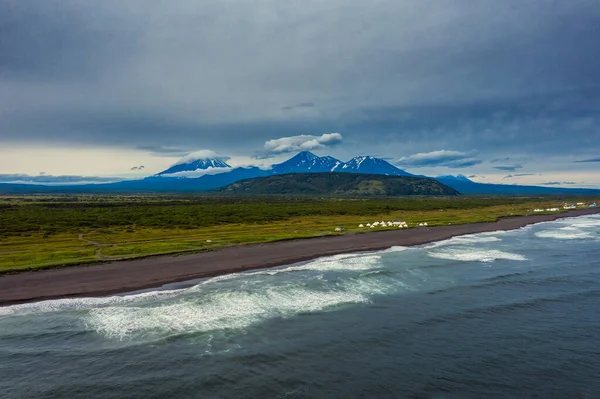 Beach with black sand and volcano — Stock Photo, Image