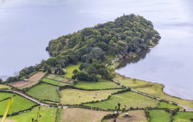 Tipik dağlık arazi Sao Miguel Island Azores, Portekiz, tamamen bazı Tarımsal alanlarda ve yeşilliklerle kaplı Sete Cidades Gölü yakınındaki. İnekler üzerine bir çayır