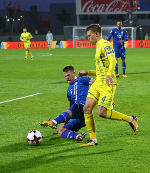 Reykjavik, İzlanda - 5 Eylül 2017: Johann Gudmundsson İzlanda (L) kavgalar bir top Mykola Matviyenko onların FIFA Dünya Kupası 2018 oyun Reykjavik, İzlanda eleme sırasında Ukrayna ile