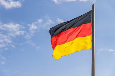 Federal Almanya Cumhuriyeti üst kısmında Alman Parlamentosu (Bundestag) Almanya'nın Berlin kentinde bina rüzgarda sallayarak bayrak. Mavi gökyüzü arka plan