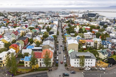 İzlanda 'nın Reykjavik şehrinin resimli hava manzarası. Şehir merkezi, merkez cadde, dağlar ve şehrin ötesindeki okyanus manzarası. Reykjavik 'teki Hallgrimskirkja Katedrali' nin tepesinden görüntü