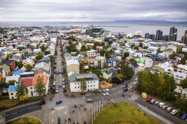 İzlanda 'nın Reykjavik şehrinin resimli hava manzarası. Şehir merkezi, merkez cadde, dağlar ve şehrin ötesindeki okyanus manzarası. Reykjavik 'teki Hallgrimskirkja Katedrali' nin tepesinden görüntü