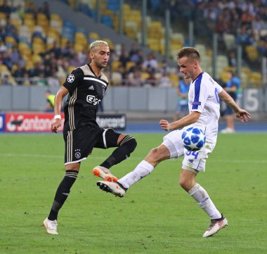 Kiev, Ukrayna - 28 Ağustos 2018: Hakim Ziyech, Afc Ajax (L) kavgalar bir top ile Tomasz Kedziora Fc Dinamo Kiev sırasında onların Milli Güvenlik Olimpiyskyi stadyum Uefa Şampiyonlar Ligi play-off maçında
