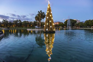Işıklı yakın çekim süslenen suya yansıyan yeni yıl ağacı. Huelin Park, Malaga şehir, Endülüs, İspanya