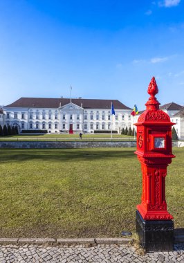 Berlin, Almanya - 25 Şubat 2015: Bellevue Palace (Schloss Bellevue) Berlin, Almanya Cumhurbaşkanı'nın resmi konutu. Bahar güneşli gün mavi gökyüzü ve yeşil çimenlerin üzerinde ön