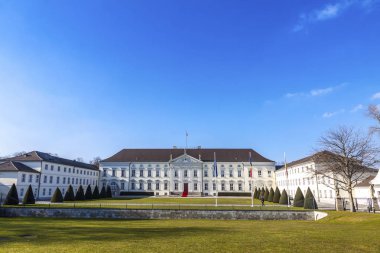 Berlin, Almanya - 25 Şubat 2015: Bellevue Palace (Schloss Bellevue) Berlin, Almanya Cumhurbaşkanı'nın resmi konutu. Bahar güneşli gün mavi gökyüzü ve yeşil çimenlerin üzerinde ön