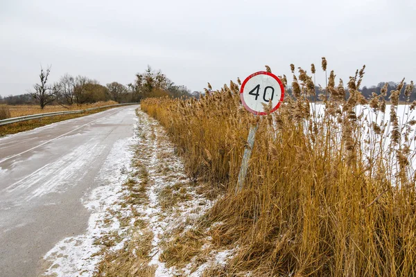 Winter road with old speed limit sign — Stock Photo, Image