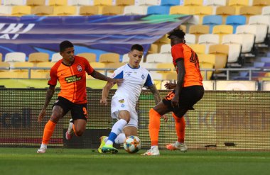 KYIV, UKRAINE - 4 Temmuz 2020: FC Dinamo Kyiv 'den Nazarii Rusyn NSC Olimpiyskiy Stadyumu' nda oynanan Ukrayna Premier Ligi maçı sırasında Dodo (L) ve Vitao of Shakhtar Donetsk ile top için mücadele ediyor.