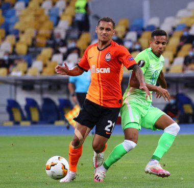KYIV, UKRAINE - 5 AĞUSTOS 2020: Shakhtar Donetsk 'li Alan Patrick (L), Kyiv' deki NSC Olimpiyskyi stadyumunda oynanan UEFA Avrupa Ligi maçı sırasında VfL Wolfsburg 'lu Joao Victor ile top için mücadele ediyor.