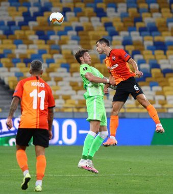KYIV, UKRAINE - 5 AUGust 2020: Shakhtar Donetsk 'ten Taras Stepanenko (R) NSC Olimpiyyi Stadyumu' nda oynanan UEFA Avrupa Ligi maçında VfL Wolfsburg (C) takımından Wout Weghorst ile top için mücadele ediyor.