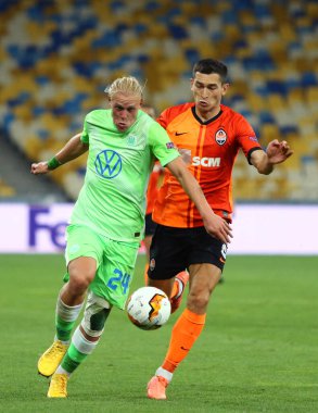 KYIV, UKRAINE - 5 AUGust 2020: VfL Wolfsburg (L) takımından Xaver Schlager, Kyiv 'deki NSC Olimpiyskyi stadyumunda oynanan UEFA Avrupa Ligi maçı sırasında Shakhtar Donetsk takımından Taras Stepanenko ile top için mücadele ediyor.