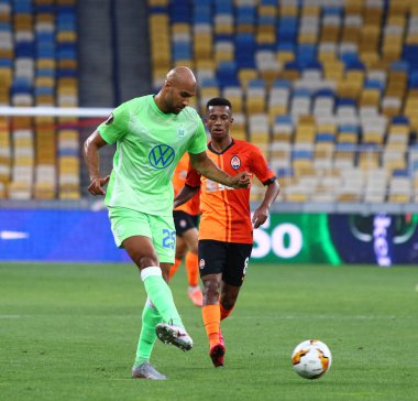 KYIV, UKRAINE - 5 AĞUSTOS 2020: VfL Wolfsburg (L) takımından John Brooks, Kyiv 'deki NSC Olimpiyskyi stadyumunda oynanan UEFA Avrupa Ligi maçı sırasında Shakhtar Donetsk' li Marcos Antonio ile top için mücadele ediyor.