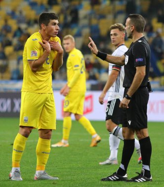 KYIV, UKRAINE - 10 Ekim 2020: Ukraynalı Ruslan Malinovskiy, NSK Olimpiyskiy Stadyumu 'nda oynanan UEFA Uluslar Ligi maçında hakem Orel Grinfeld' e sarı kart gösterdi.
