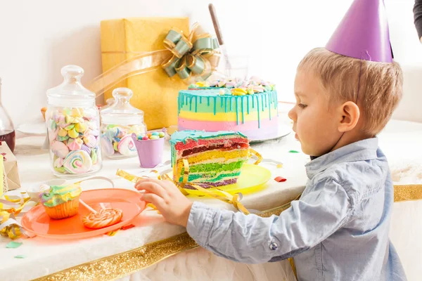 Mignon garçon avec chapeau de fête veut gâteau sucré — Photo