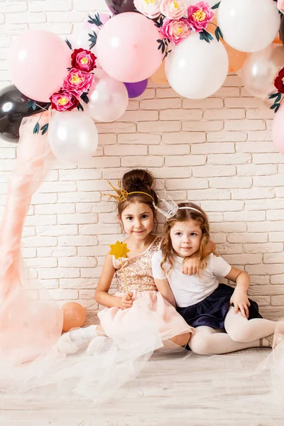 Маленькие принцессы сидят под воздушными шарами — стоковое фото