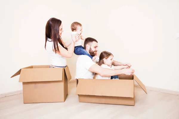 Family unpacking cardboard boxes at new home — Stock Photo, Image