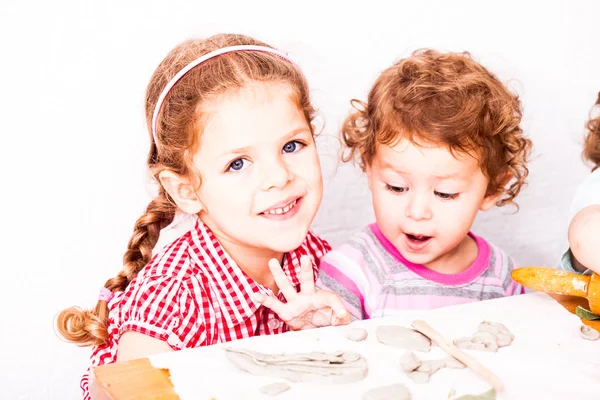 Crianças felizes estão envolvidas com argila de modelagem — Fotografia de Stock