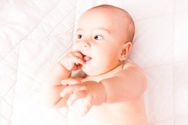 Ağzına bir parmak ile yürümeye başlayan çocuk