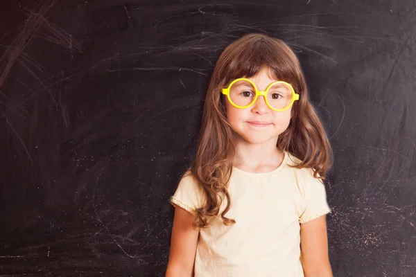 黒板から幸せな小さな女の子女子高生 — ストック写真