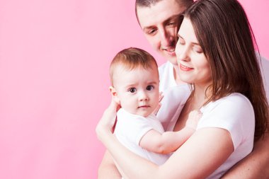 Kameraya bakarak veliler kollarında şirin bebek