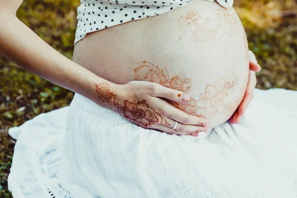 Mit mehndi den schwangeren bauch verschließen — Stockfoto