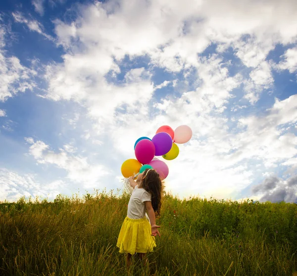 Glückliches Kind mit bunten Luftballons — Stockfoto