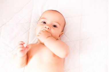 Ağzına bir parmak ile yürümeye başlayan çocuk