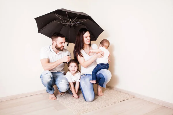 Οικογένεια κάθεται κάτω από την ομπρέλα — Φωτογραφία Αρχείου