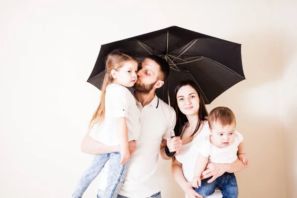 Привлекательная семья стоит под зонтиком — стоковое фото