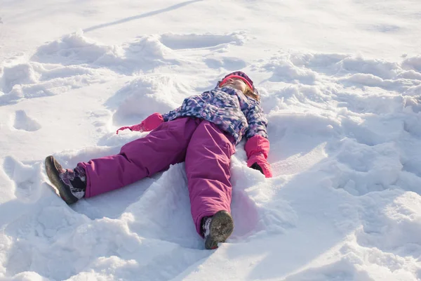 Chica hace ángel de nieve — Foto de Stock