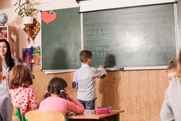 De schooljongen antwoorden op de les — Stockfoto