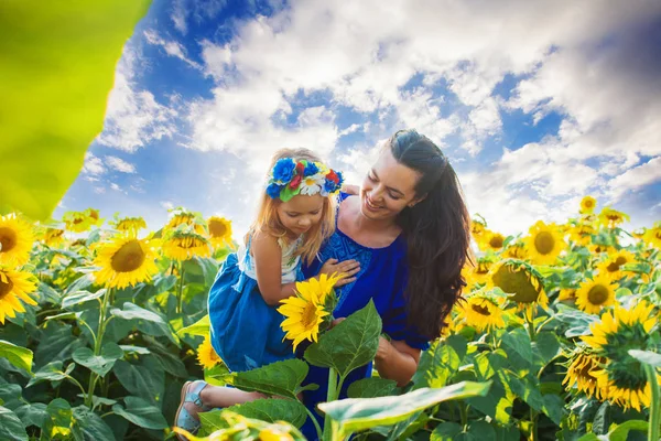 Mamma och dotter bland solrosor — Stockfoto