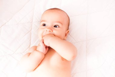 Ağzına bir parmak ile yürümeye başlayan çocuk