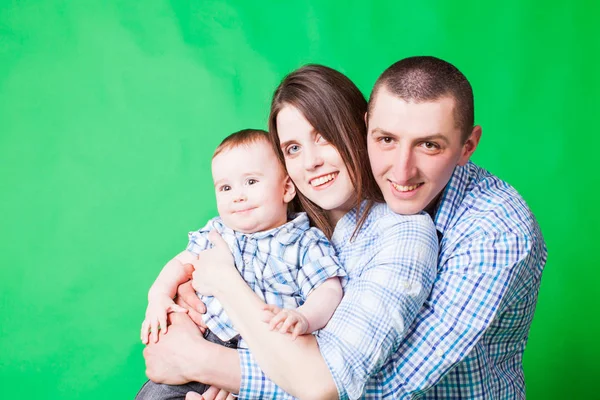Молодой семейный портрет на зеленой букве б — стоковое фото