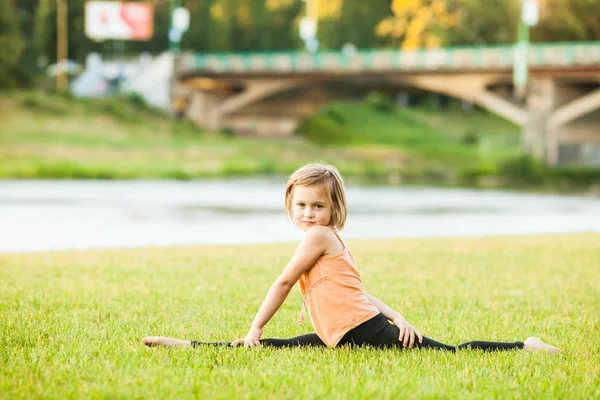 公園でストレッチをやって幸せな女の子を訓練します。 — ストック写真