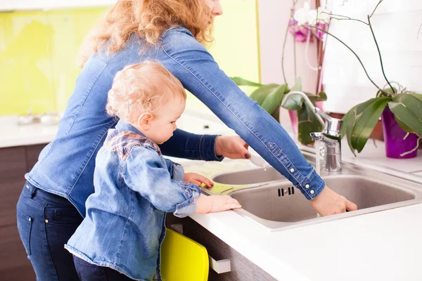Madre con un niño lavando platos —  Fotos de Stock