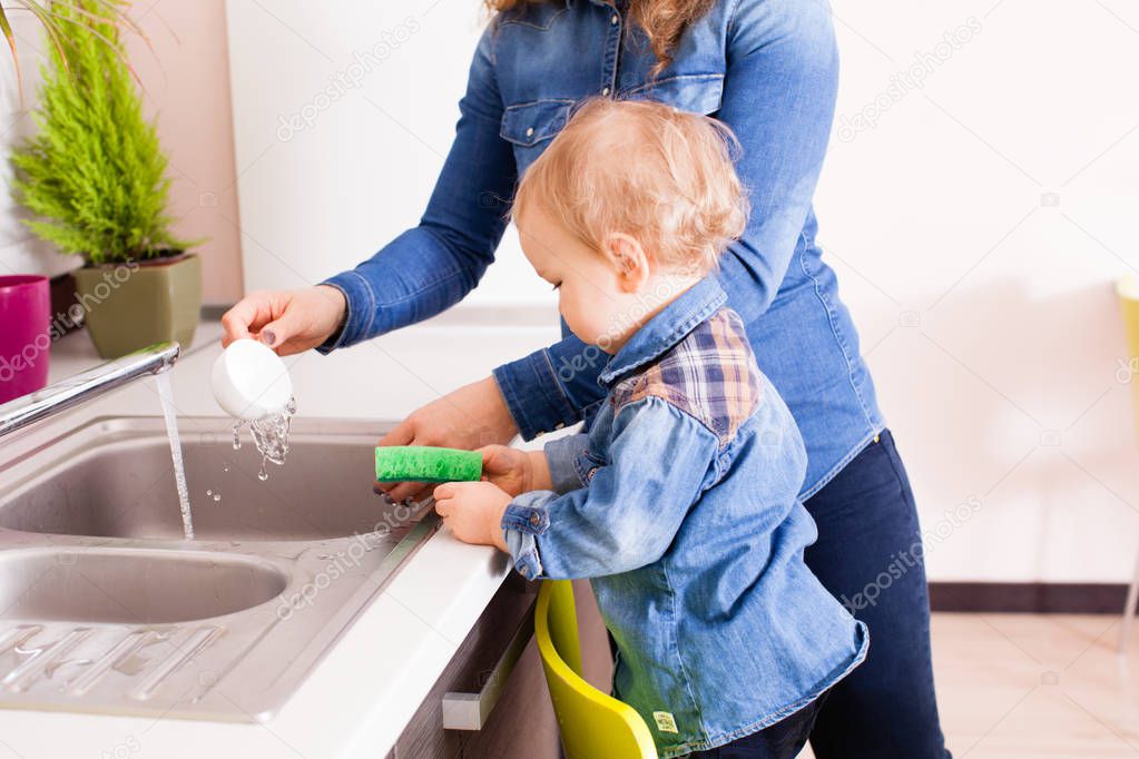 Baby boy washing dishes