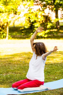 Güzel hamile kadın açık antrenman yaparken rahatlatıcı
