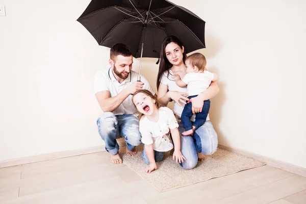 Οικογένεια αισθάνεται ασφαλής κάθεται κάτω από την ομπρέλα — Φωτογραφία Αρχείου