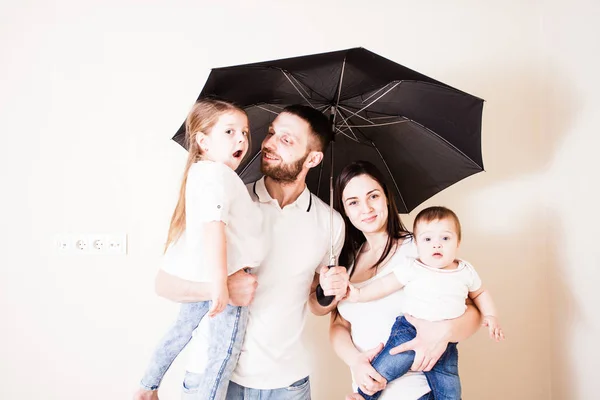 Happy family feeling safe under umbrella
