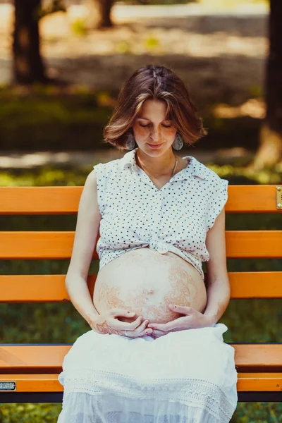 Retrato de la joven embarazada feliz sentada en un banco —  Fotos de Stock