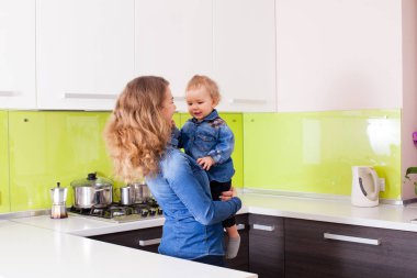 Holding onların mutfak onun kollarında küçük çocukta anne