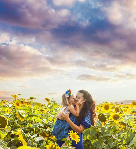 Mutter und Tochter zwischen Sonnenblumen — Stockfoto