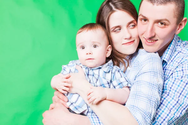 Young family portrait isolated on a green background — Stock Photo, Image
