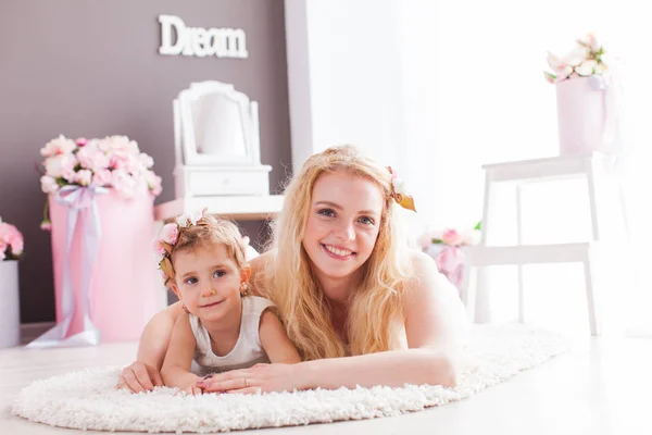 Feliz hija sonriente y mamá tendidas en el suelo en su casa — Foto de Stock